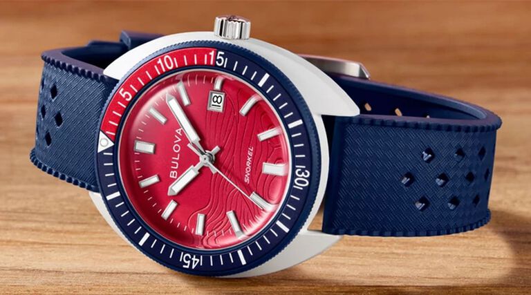 New Arrival Watches; Featuring an image of Snorkel Sail 4th watch model 98B474 on a wood tabletop background