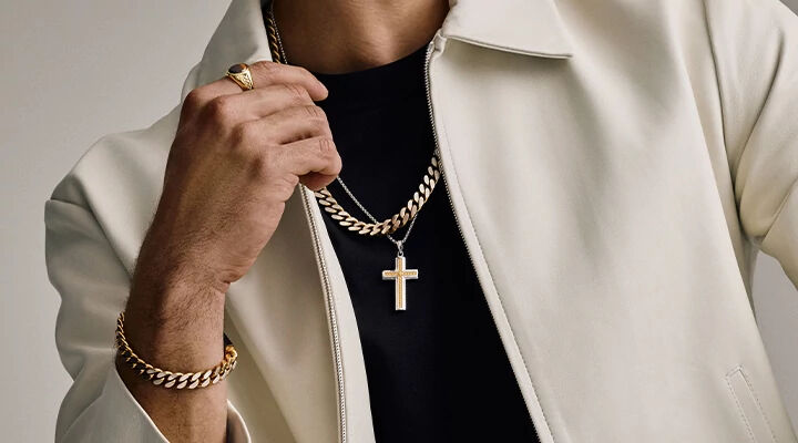 Man Wearing White Jacket with Bulova Chain Necklace Layered with Cross Pendant and Bulova Link Bracelet and Ring